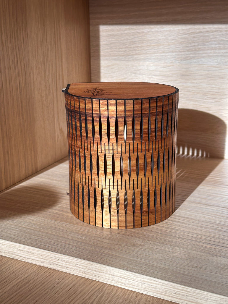 Wooden table lamp with wavy pattern on a wooden shelf