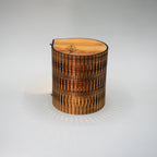 Wooden cylindrical lamp with a textured surface on a light gray background