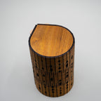 Wooden cylindrical lamp with a textured surface on a white background