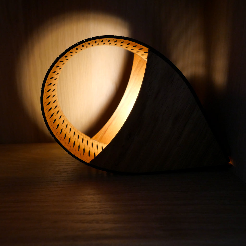 Timber Droplet lamp with a warm halo glow on a dark background