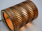 Bubble Lamp in Timber: wooden cylindrical lamp with diamond cutouts and warm orange glow