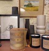 Decorative candles, vases and RS Studio bubble lamp on a table with a painting and framed picture in the background.