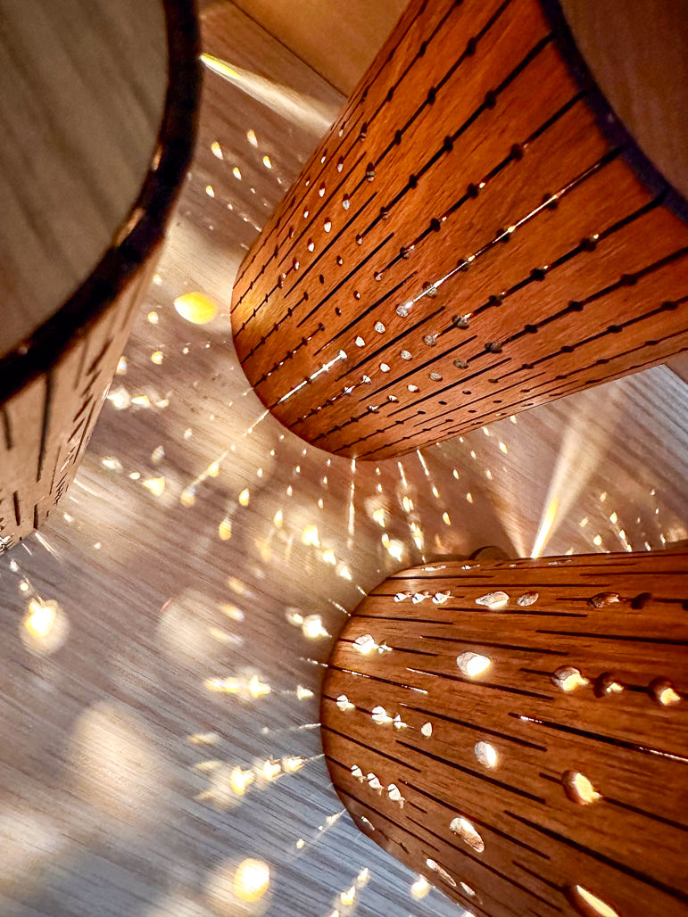 Wooden lamps with light filtering through, creating a warm glow.