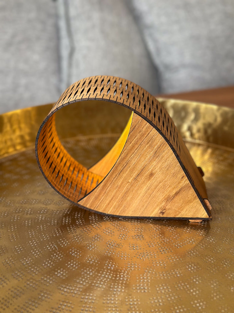 Wooden droplet lamp with geometric design on a textured gold surface
